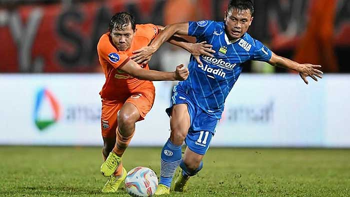 Duel perebutan bola antara Adam Alis (Borneo FC) dengan Dedi Kusnandar (Persib Bandung) dalam laga yang berakhir imbang.