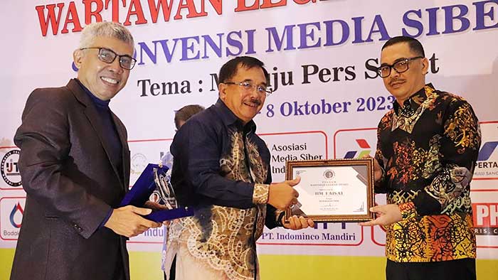 DEDIKASI: Faisal (kanan) menerima penghargaan dari Wartawan Legend Award. (foto: istimewa)