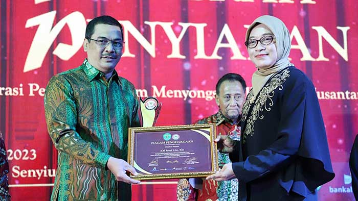 BERPRESTASI: M Faisal (kiri) menerima penghargaan dari KPID Award 2023 yang diserahkan Sekprov Kaltim Sri Wahyuni. (foto: istimewa)