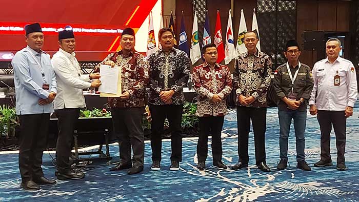 Fahmi Idris didampingi oleh anggota KPU dan Bawaslu menyerahkan SK Penetapan Pasangan Calon Terpilih Pilgub Kaltim kepada Rudy Mas'ud dan Seno Aji.