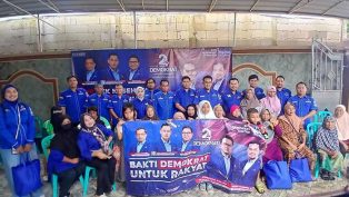 Pengurus DPD Partai Demokrat Kaltim berfoto bersama dengan warga masyarakat yang mendapatkan sembako. (foto: reza)