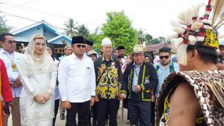 Rudy Mas'ud dan Istri saat disambut warga Dayak dengan upacara adat sebelum memasuki Lamin Etam.